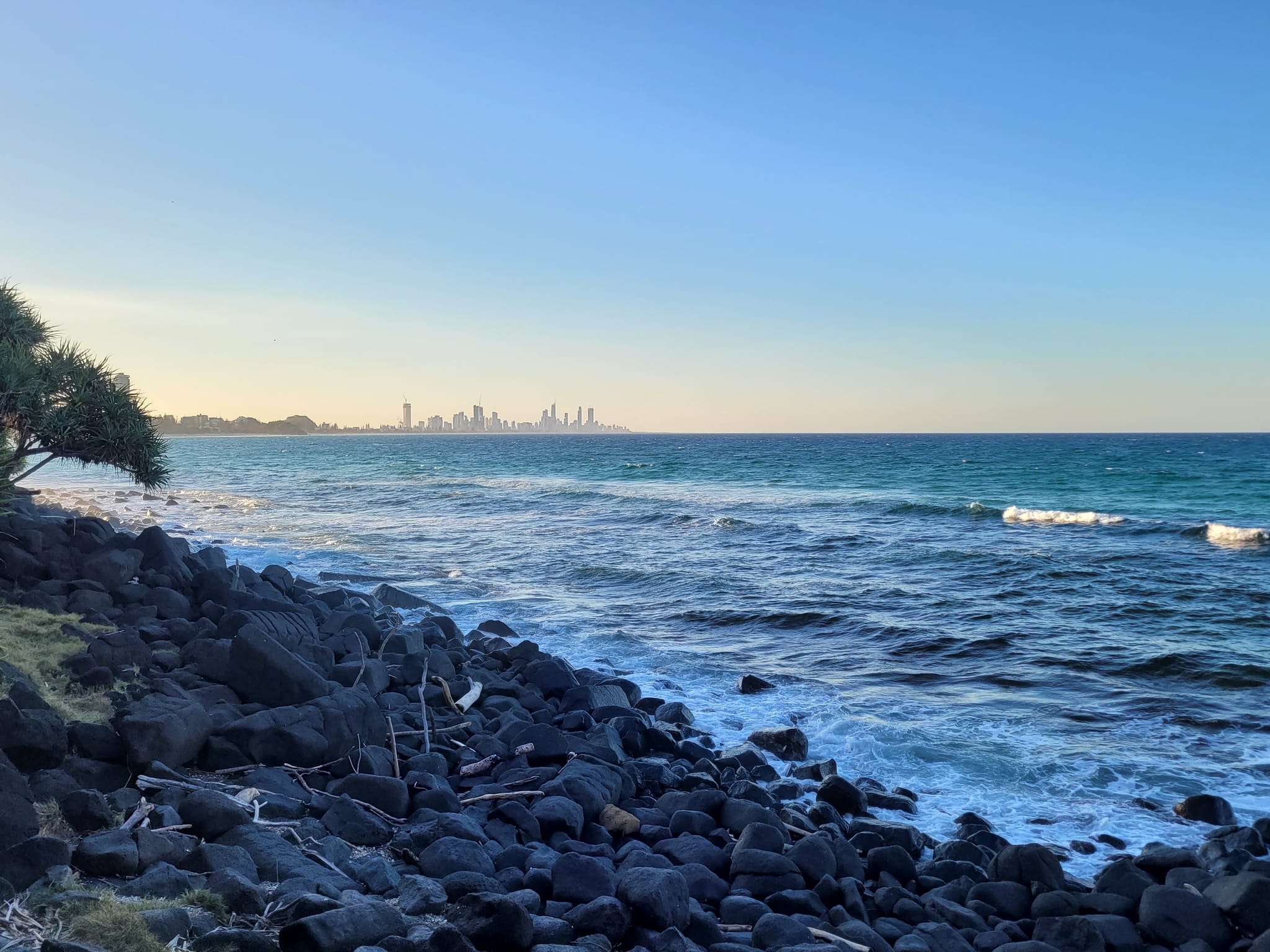 The rocky shore at Burleigh Heads looking north over the ocean towards the Gold Coast skyline