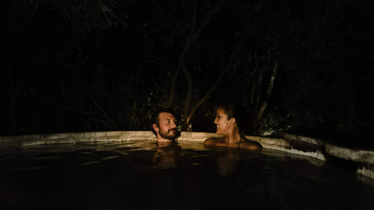 A couple enjoy the moonlit bathing experience at the Peninsula Hot Springs. 